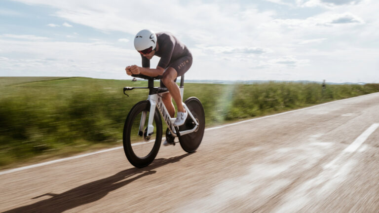 Triathlete riding a time trial bike wearing a Ryzon tri suit